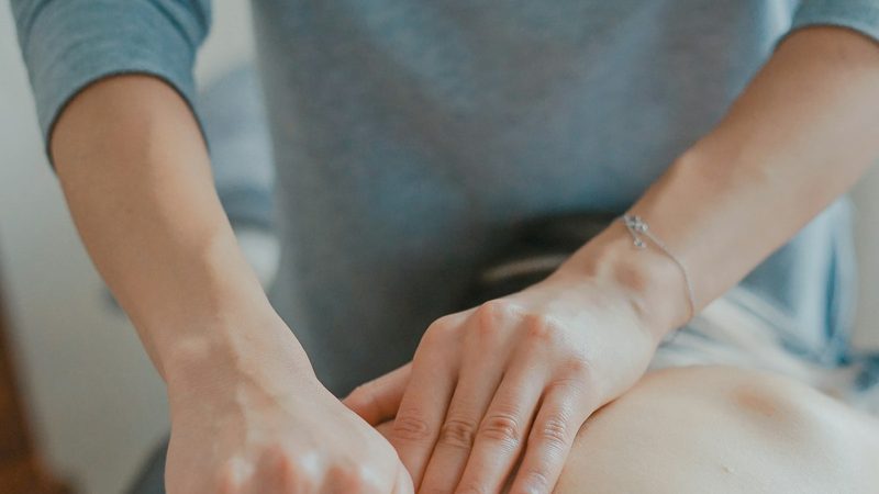 A chiropractor gently adjusting a patient's back
